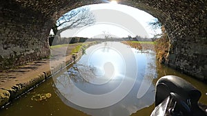 View of a British canal in rural setting with stone bridge