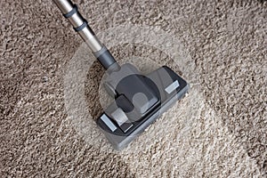 View of brush of vacuum cleaner on dirty carpet at home