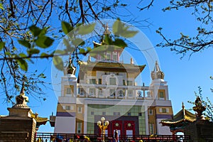 View of the Buddhist temple Golden Abode of Buddha Shakyamuni behind the fence and trees. Elista, Republic of Karelia, Russia