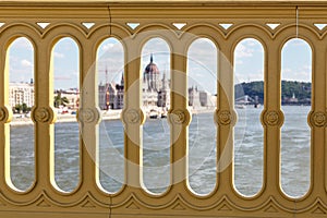 View of the building of the Hungarian Parliament and the Danube River through the fence of the bridge. Budapest, Hungary. Sunny