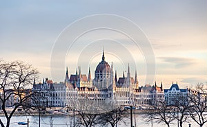 View of the building of the Hungarian Parliament illuminated by the rays of the setting sun. In Budapest, Hungary