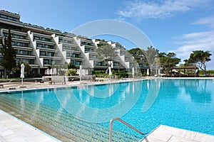 View of the building of a modern luxury hotel and a large pool i