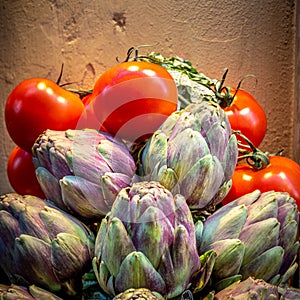 View of bunch of red tomatoes and artichokes