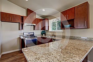 View of burgundy kitchen cabinets with granite counter top