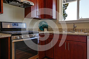 View of burgundy kitchen cabinets with granite counter top