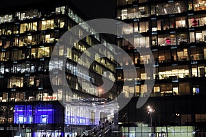 View of the burning windows of the office building at night. The work of people in the office. Urban night landscape