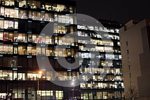 View of the burning windows of the office building at night. The work of people in the office. Urban night landscape