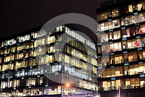 View of the burning windows of the office building at night. The work of people in the office. Urban night landscape