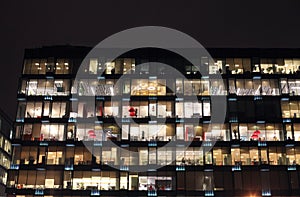 View of the burning windows of the office building at night. The work of people in the office. Urban night landscape