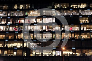 View of the burning windows of the office building at night. The work of people in the office. Urban night landscape