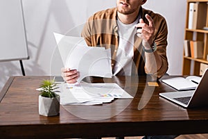 View of businessman holding papers near