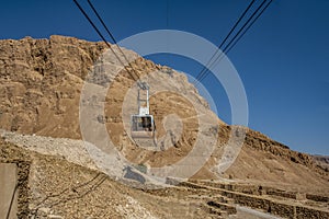 View of the cable car from a low point of view over Mount Massada Israel, the bottom construction, the ruins.