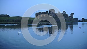 View of Caerphilly Castle, Wales, with brids flying on the lake, in th