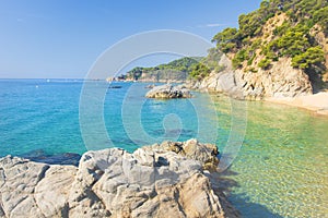 View on Cala sa Boadella platja on sunny summer day in Lloret de Mar, Costa Brava, Spain. Paradise lagoon beach. Spanish resorts photo