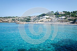 View of Cala Tarida with rocks in turquoise sea water, Ibiza island, Spain photo