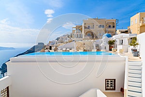 A view of caldera with luxury hotel buildings, typical white architecture of Firostefani village on Santorini island, Greece