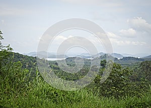 View of a calm mighty river, flowing between low mountains. Kra Buri River