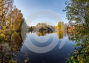 view of a calm river, autumn, Sunny day. In the foreground are beautiful twigs and leaves. Reflection