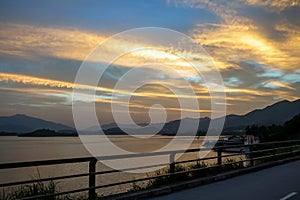 The view of the calm seascape in the shore under the colorful sunset.