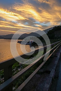 The view of the calm seascape in the shore under the colorful sunset.