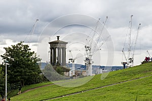 View from Calton hill with ugald steward Monument to the old town of Edinburgh with building cranes