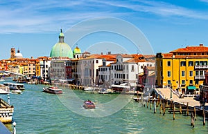 View of the canal with boats and gondolas in Venice, Italy. Venice is a popular tourist destination of Europe