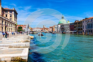 View of the canal with boats and gondolas in Venice, Italy. Venice is a popular tourist destination of Europe