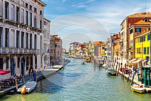 View of the canal with boats and gondolas in Venice, Italy. Venice is a popular tourist destination of Europe