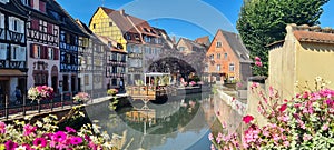 View on the canal framed by colourful flowers in little Venice in Colmar, Alsace, France