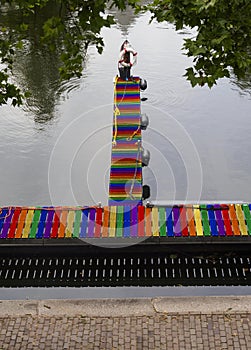 View of the canal, pier and platform with lifebuoy in the colors of the LGBT flag in Netherlands