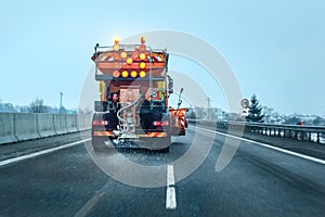 View from the car behind orange highway maintenance truck