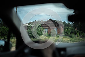 View from a car cabin on an old wooden building