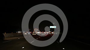 View from the car. Los Angeles busy freeway at night time. Massive Interstate Highway Road in California, USA. Auto