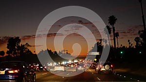 View from the car. Los Angeles busy freeway at night time. Massive Interstate Highway Road in California, USA. Auto