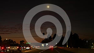 View from the car. Los Angeles busy freeway at night time. Massive Interstate Highway Road in California, USA. Auto