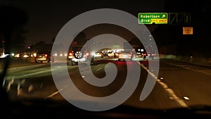 View from the car. Los Angeles busy freeway at night time. Massive Interstate Highway Road in California, USA. Auto