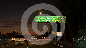 View from the car. Los Angeles busy freeway at night time. Massive Interstate Highway Road in California, USA. Auto driving fast