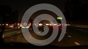 View from the car. Los Angeles busy freeway at night time. Massive Interstate Highway Road in California, USA. Auto driving fast