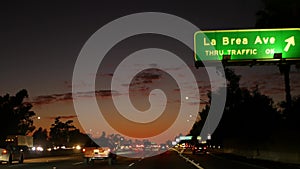 View from the car. Los Angeles busy freeway at night time. Massive Interstate Highway Road in California, USA. Auto driving fast