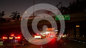 View from the car. Los Angeles busy freeway at night time. Massive Interstate Highway Road in California, USA. Auto driving fast