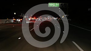 View from the car. Los Angeles busy freeway at night time. Massive Interstate Highway Road in California, USA. Auto driving fast