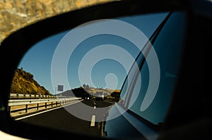 View in the car mirror on fast road in the Spain, beautiful land