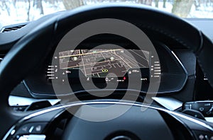 View of the car navigation display with city map through the steering wheel