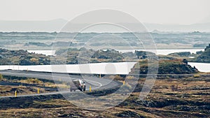 View of a car on the road in a volcanic landscape captured in MÃ½vatn, Iceland