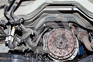 View of the car`s clutch basket during the repair of a car lifted on a lift in a vehicle maintenance workshop. Industry in the