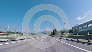 View from car on suburban highway. Scene. Highway at entrance to city with beautiful view of asphalt road, mountains on