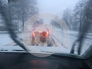 View from car window driving in heavy snow fall during winter travel from work to home