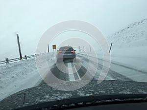 View from car window driving in heavy snow fall during winter travel from work to home