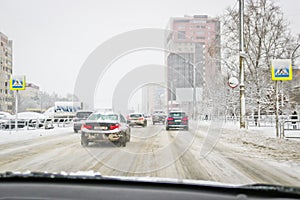 View from the car window during rain and wet snow. Poor visibility while driving around the city. Snowy road