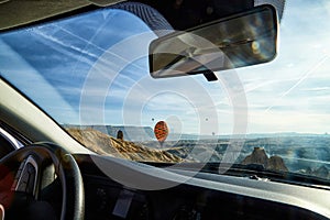 View from car window on the road and strange landscape with a valley, mountains and blue sky with clouds. Landscape through